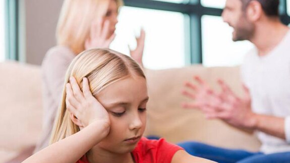 Una niña, junto a sus padres discutiendo.