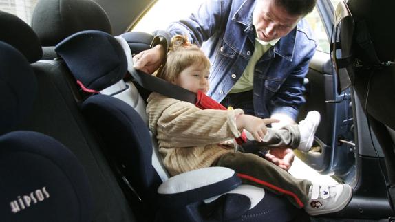 Un adulto fija a la silla para niños