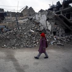 Una niña siria camina junto a casas destruidas en Douma, a las afueras de Damasco.
