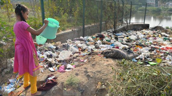 Una niña recoge basura en Bangalore. 