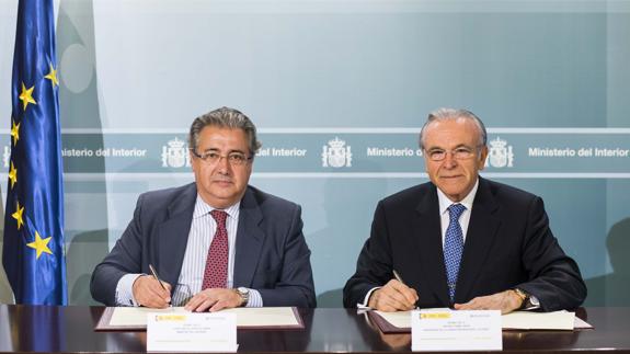 Juan Ignacio Zoido, ministro del Interior, e Isidro Fainé, presidente de la Fundación La Caixa firman el acuerdo.
