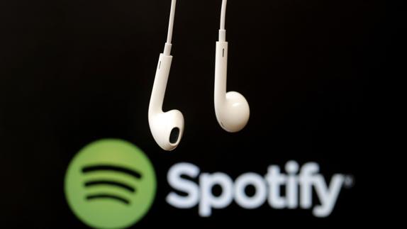 Auriculares frente al logotipo de Spotify.