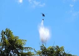 Un helicóptero trabaja sobre una columna de humo en la zona del arroyo Blanquillo. Pedro García