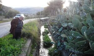 El secretario de Aprema, junto una una acequia