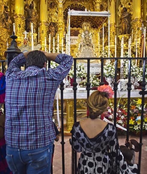 Dos devotos de la Virgen del Rocío observan la imagen horas antes del salto de la reja. 