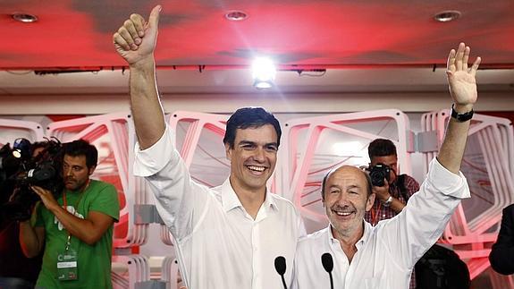 Sánchez y Rubalcaba saludan a los militantes del PSOE tras conocerse los resultados de las primarias el 13 de julio.