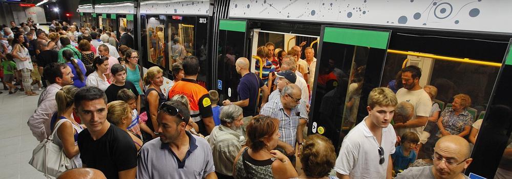 La comitiva pasa los tornos para salir de la estación El Perchel tras la apertura comercial de las líneas 1 y 2