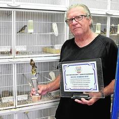 Miguel Herrero, con varios de los trofeos conseguidos, junto a las jaulas donde cría pájaros exóticos. 
