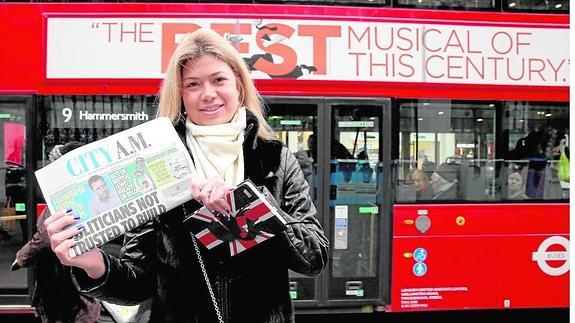 Una joven muestra el ejemplar de ayer de ‘City AM’ en la calle Strand, al lado de Trafalgar. 