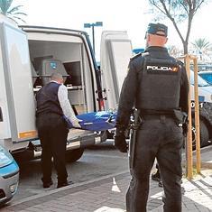 Operarios de la funeraria judicial retiran el cadáver ante la mirada de unos policías.