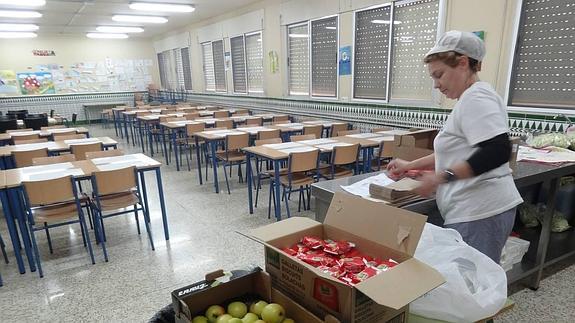 La cocinera del colegio Moreno Villa comienza a preparar las bolsas para la merienda. 