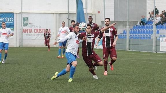 Apoño disputa el balón con un contrario durante el partido de ayer.