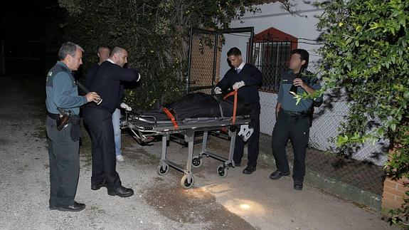 Empleados de la funeraria judicial retiran el cadáver de uno de los fallecidos.