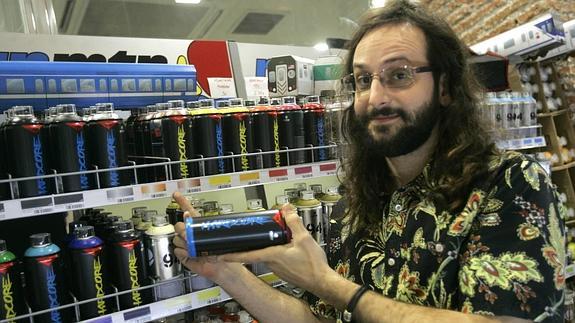 El dueño de la tienda, Manuel Criado, muestra la estantería de botes de pintura.