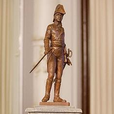 Maqueta del momumento de Teodoro Reding, junto a un miembro de la asociación con el uniforme que vestía este regimiento suizo en 1808. 