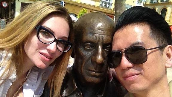  Una pareja de neoyorquinos llegados en crucero, Victoria y Zih, con la estatua de Picasso en la plaza de la Merced en Málaga. 