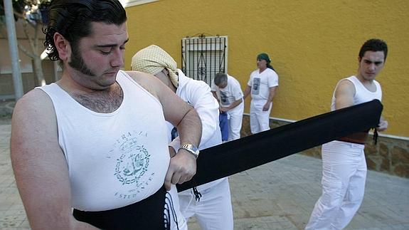 Costaleros se preparan para llevar un paso. 