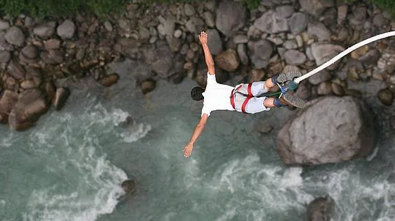 Un aficionado pone a prueba su adrenalina practicando ‘puenting’ sobre un río.