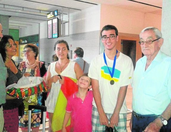 La familia recibe a Ángel, con la medalla, en el aeropuerto.
