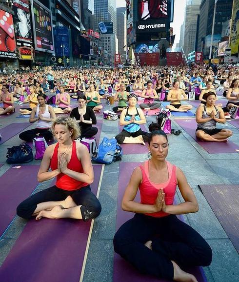 Un grupo de aficionados practica yoga en Time Square, en Nueva York.