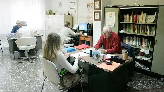 Santiago Martínez (en primer término) atiende una consulta en la oficina del Centro de Orientación Familiar, en la Alameda.