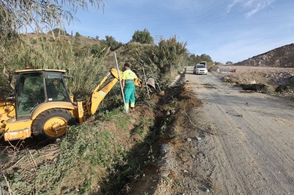 Trabajadores, ayer, actuando sobre las cunetas del carril que da acceso al vertedero municipal. 