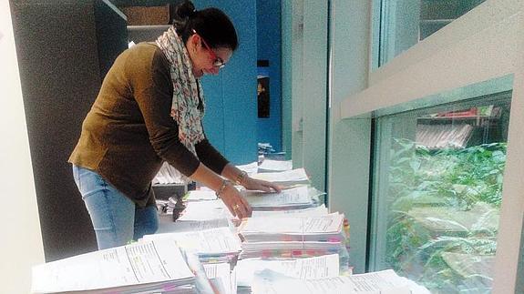 Una funcionaria revisa los expedientes de los casos acumulados en el juzgado. 