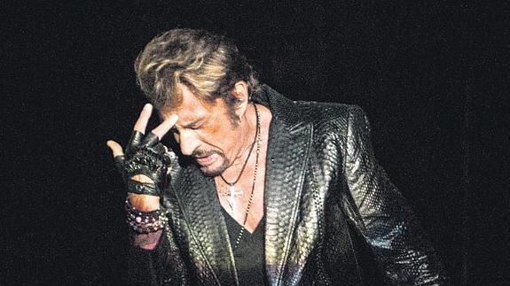 Johnny Hallyday, de cuero y negro rigurosos, en una pose clásica durante un concierto en 2012 en Canadá. / Afp