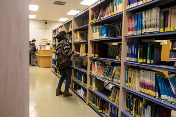 Una estudiante busca un libro en las nuevas estanterías de la biblioteca de Medicina. 