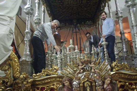 El albacea general, Antonio Centeno, a la derecha, con parte de su equipo en lo alto del trono de la Virgen de la Paloma.:: eduardo nieto