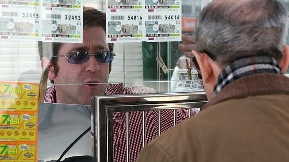 Un lotero atiende a un cliente.