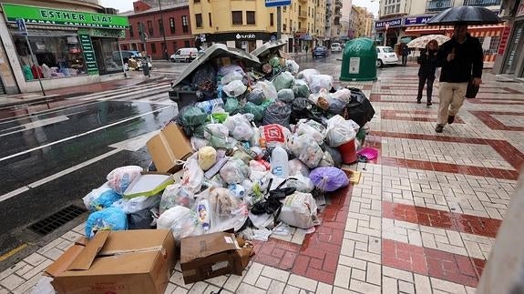 Basura acumulada ayer  junto a un contenedor en calle Mármoles. 