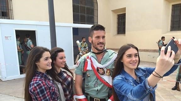 Jóvenes haciéndose una foto con un legionario. 