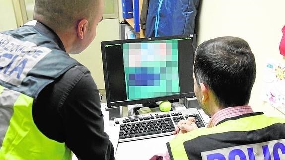 Dos agentes del Cuerpo Nacional de Policía investigan en las redes sociales.