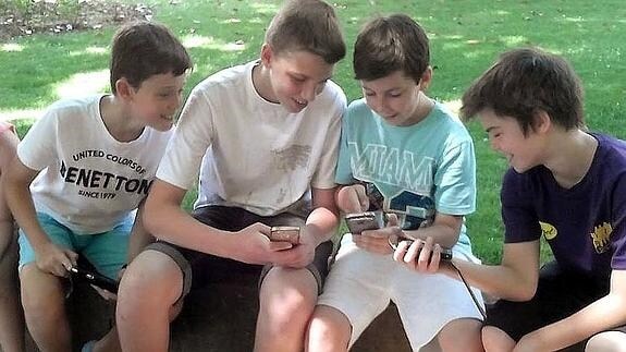 Jóvenes adolescentes se entretienen con sus teléfonos móviles en una imagen de archivo.
