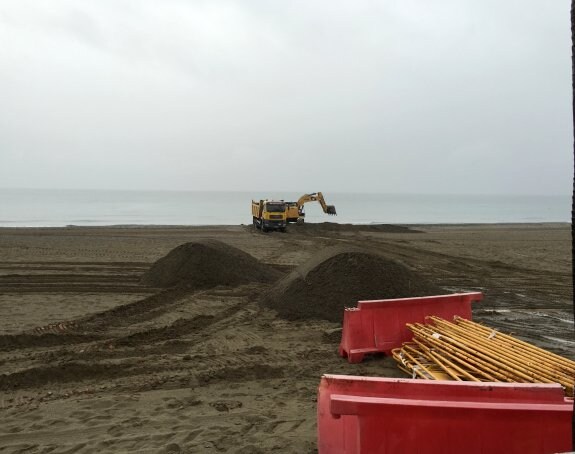 Máquinas excavadores recogen arena en La Rada para rellenar otras playas. 