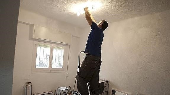 Un operario coloca una lámpara en uno de los pisos. 