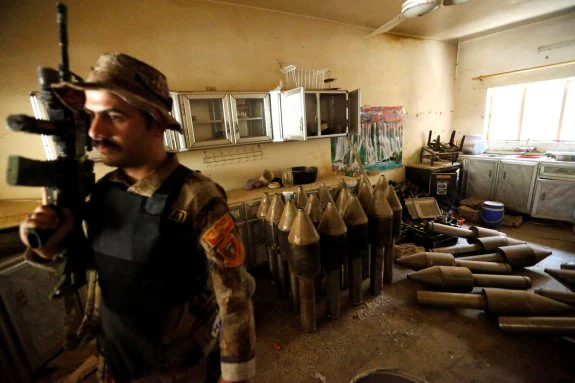 Un soldado iraquí junto a armas decomisadas a los yihadistas. :: reuters
