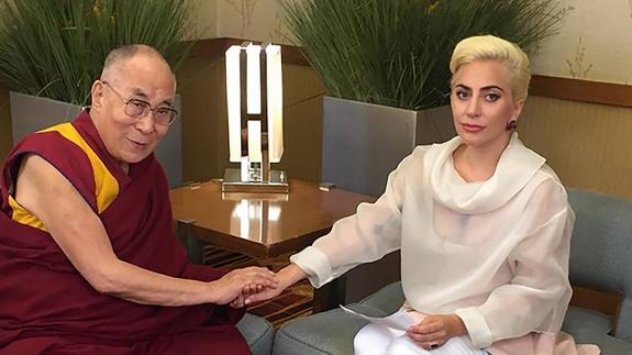 El Dalái Lama estrecha la mano de la artista estadounidense Lady Gaga. 