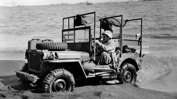 Un Jeep adaptado como ambulancia se abre paso en la arena de una playa en 1945.