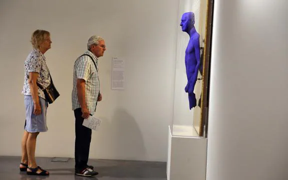Dos visitantes contemplan el retrato-relieve de Arman realizado por Yves Klein