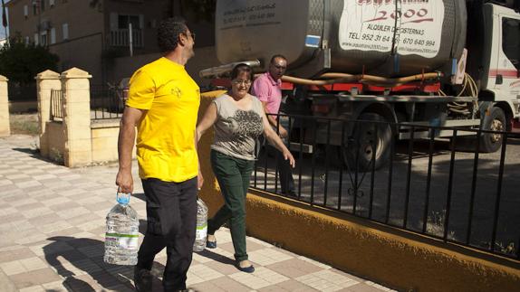 Vecinos de Fuente de Piedra acarrean garrafas de agua. 