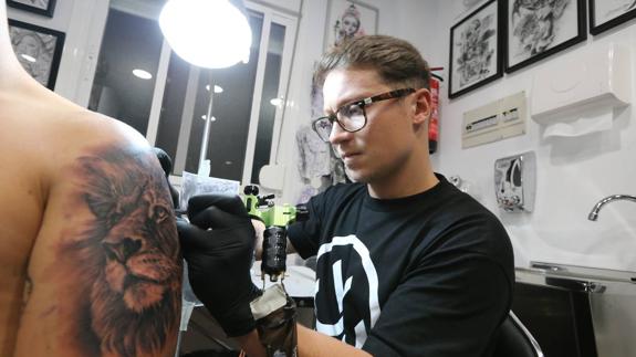 Sergio Fernández realiza uno de sus tatuajes en su estudio de Mangas Verdes. 