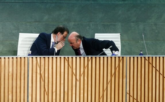 Mariano Rajoy y Luis de Guindos, durante la presentación de 'España amenazada'. :: o. del pozo