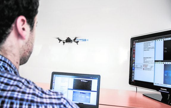 Un trabajador de Ayesa junto a un dron en vuelo.