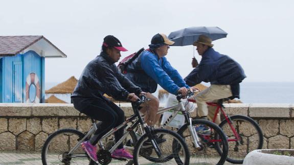 Deportistas desafían a la lluvia para moverse en bicicleta este miércoles en Málaga.