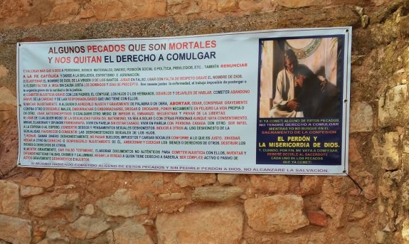 Pancarta colgada en la fachada de la iglesia con la lista de pecados por el párroco de Viveros (Albacete). :: R. C.