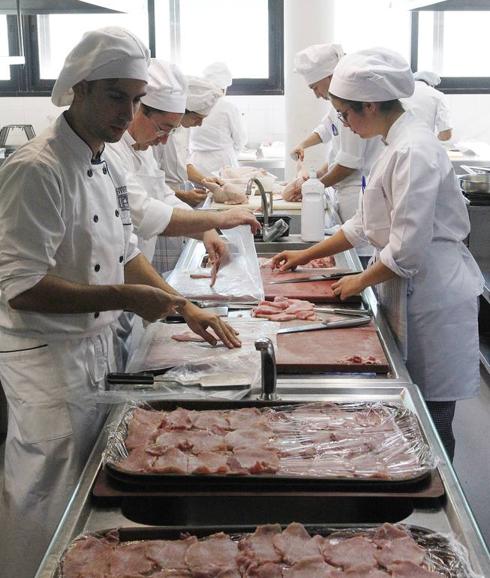 Alumnos de primero preparan filetes para empanar. 