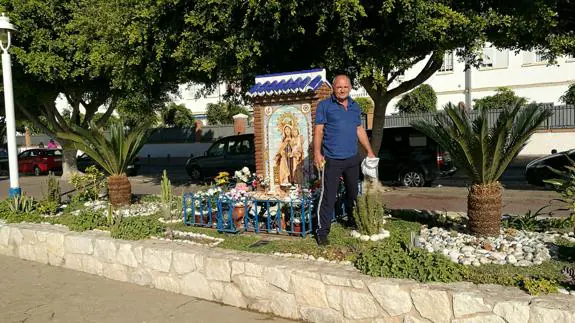 Juan Caparrós, junto a las plantas que ha sembrado y el mosaico de la Virgen del Carmen en el paseo marítimo de El Palo.