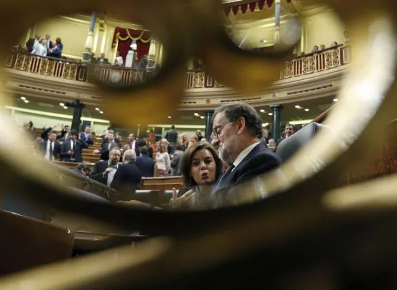 Mariano Rajoy conversa con Soraya Sáenz de Santamaría durante el debate de investidura del líder del PP en octubre. :: JAVIER LIZÓN / EFE